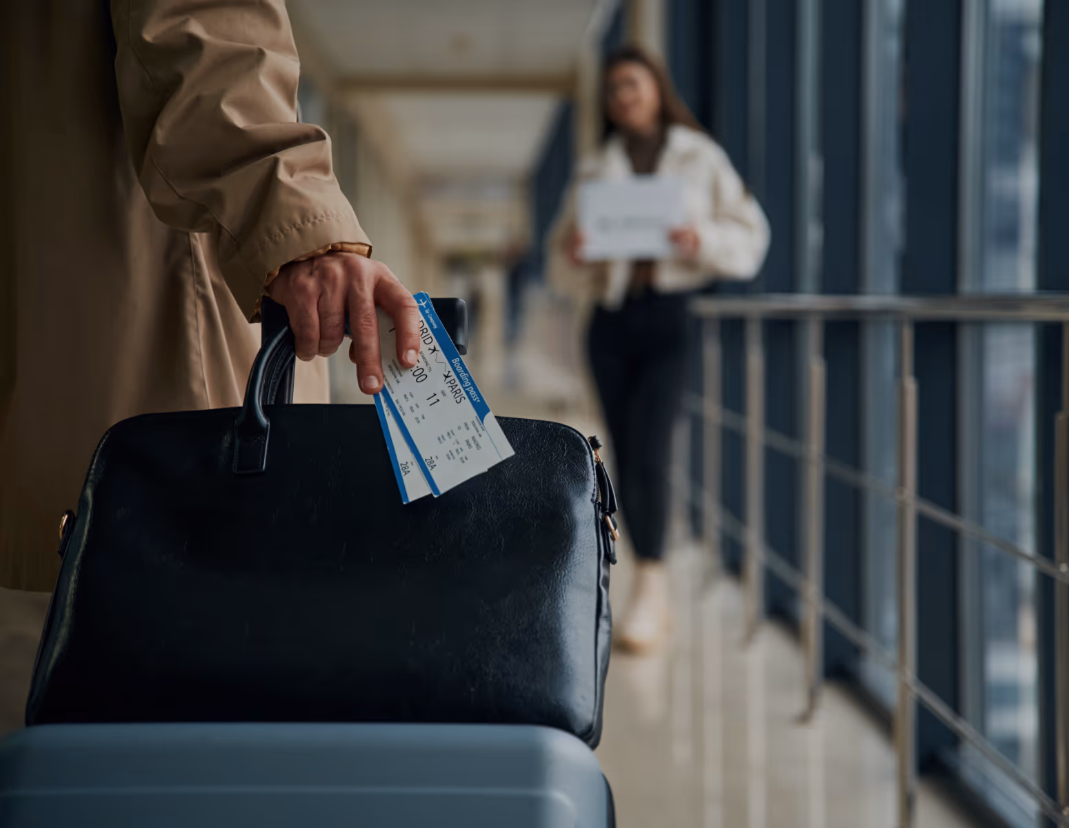 Traveller carrying a bag and boarding pass through a terminal